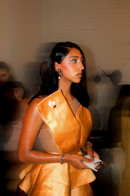 Stylist Sonsa backstage in a gold satin top